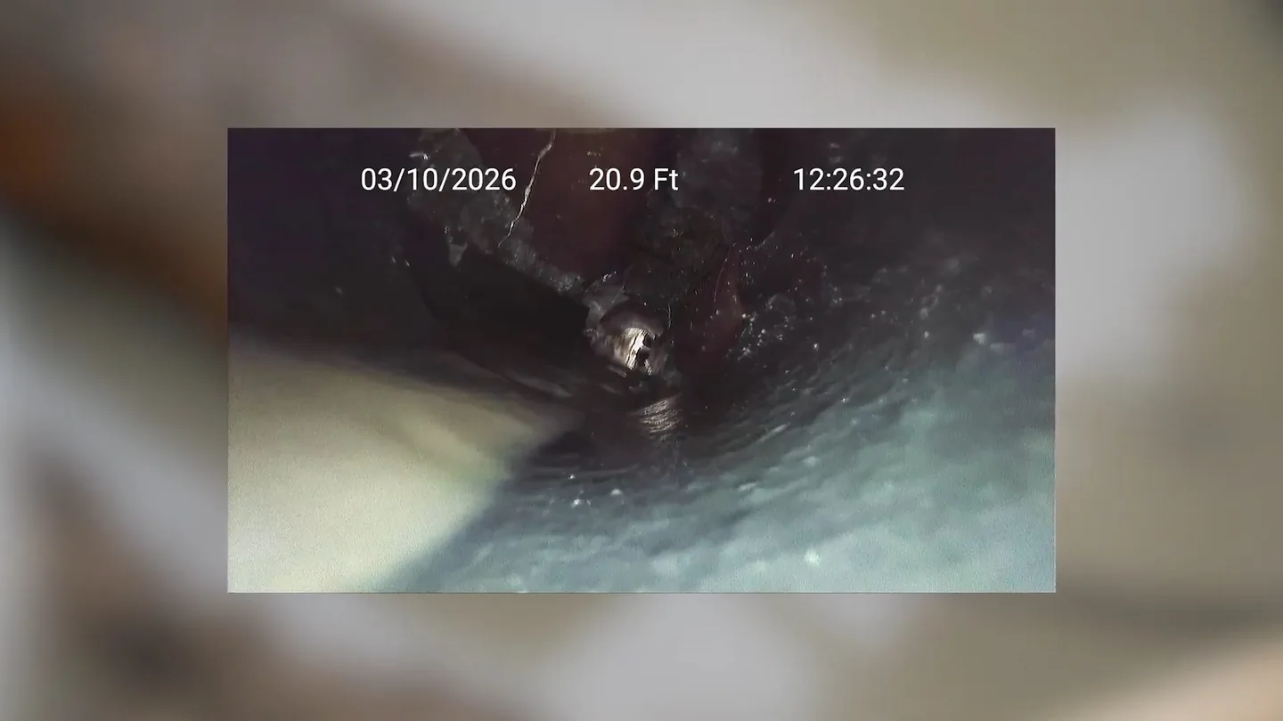 Sewer camera screen showing a date stamp, a distance reading of 20.9 feet and the dark inside of a pipe.